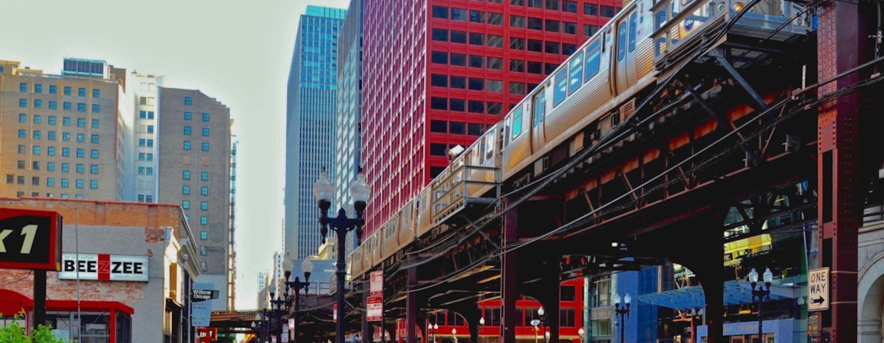 Chicago L train on elevated tracks with city skyline - chicago apartments near transit